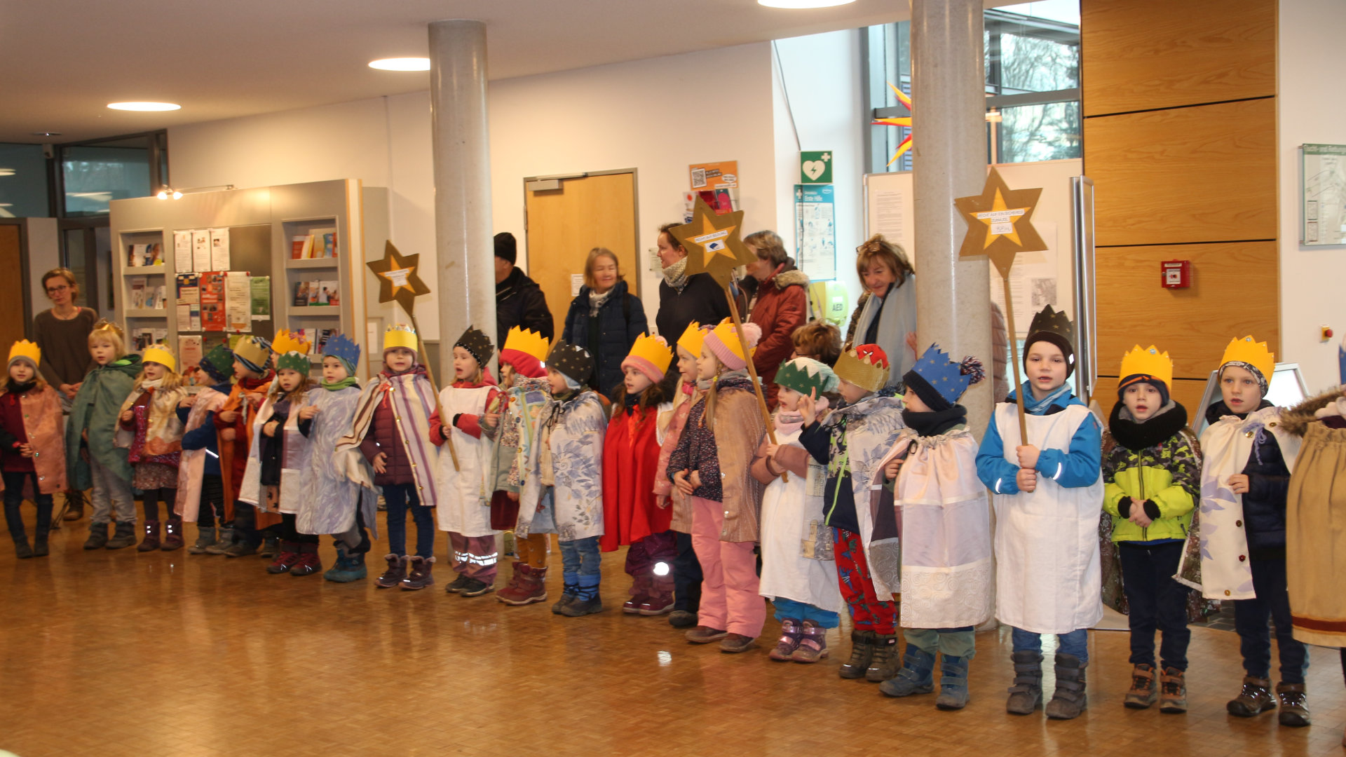 Sternensinger Kinger mit gebastelten Kostümen und einer Krone viele Kinder in einer Reihe im Rathaus Coswig im Januar 2025