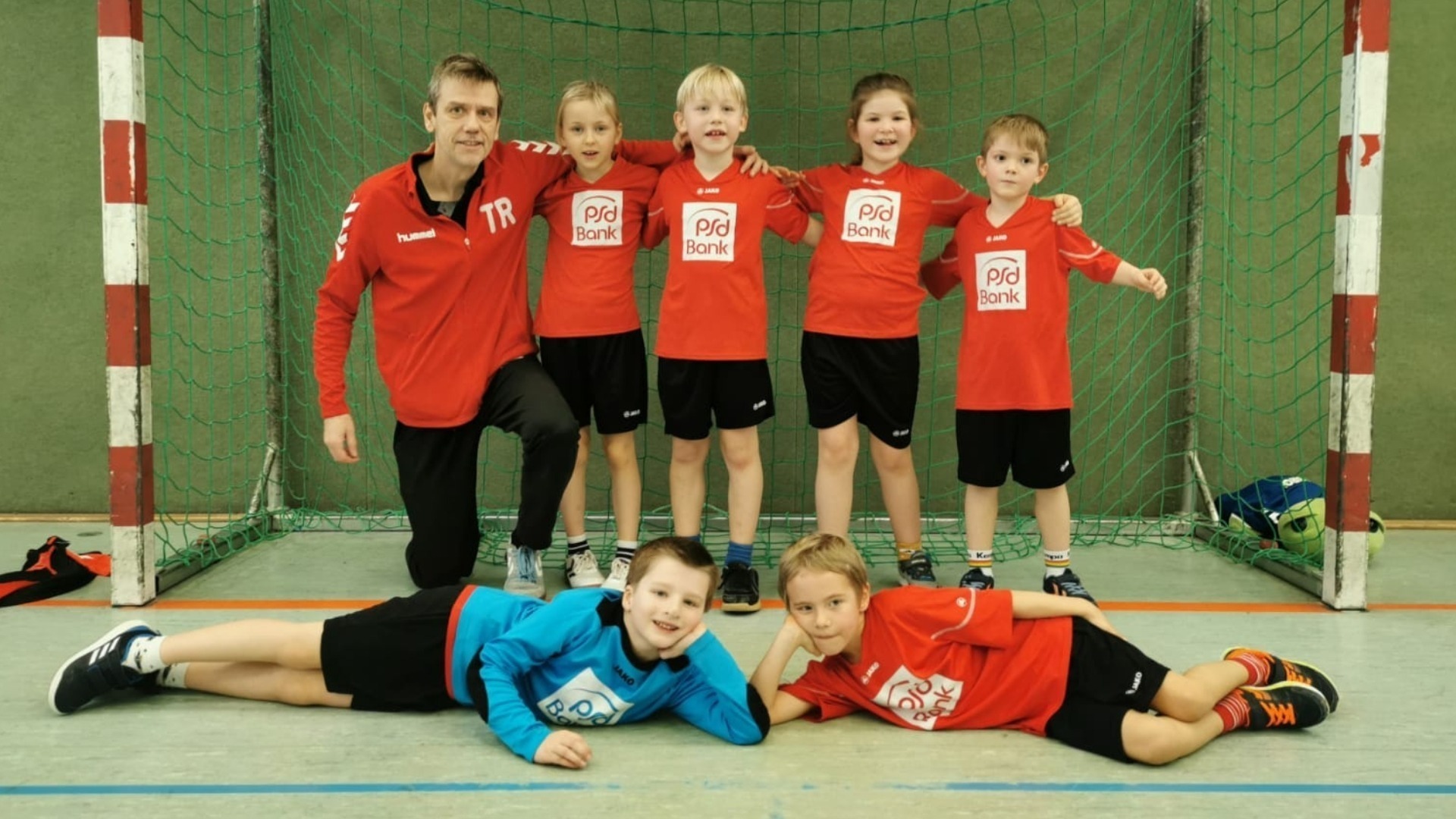 Radebeuler Minis Kinder Handballspieler und ein Trainer stehen vor einem Tor in der Handballhalle im Februar 2025