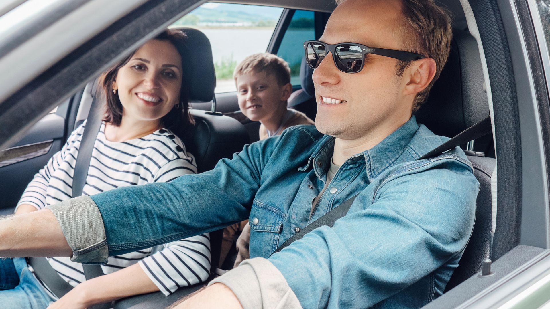 Familie sitzt im Auto an einem Sonnigem Tag