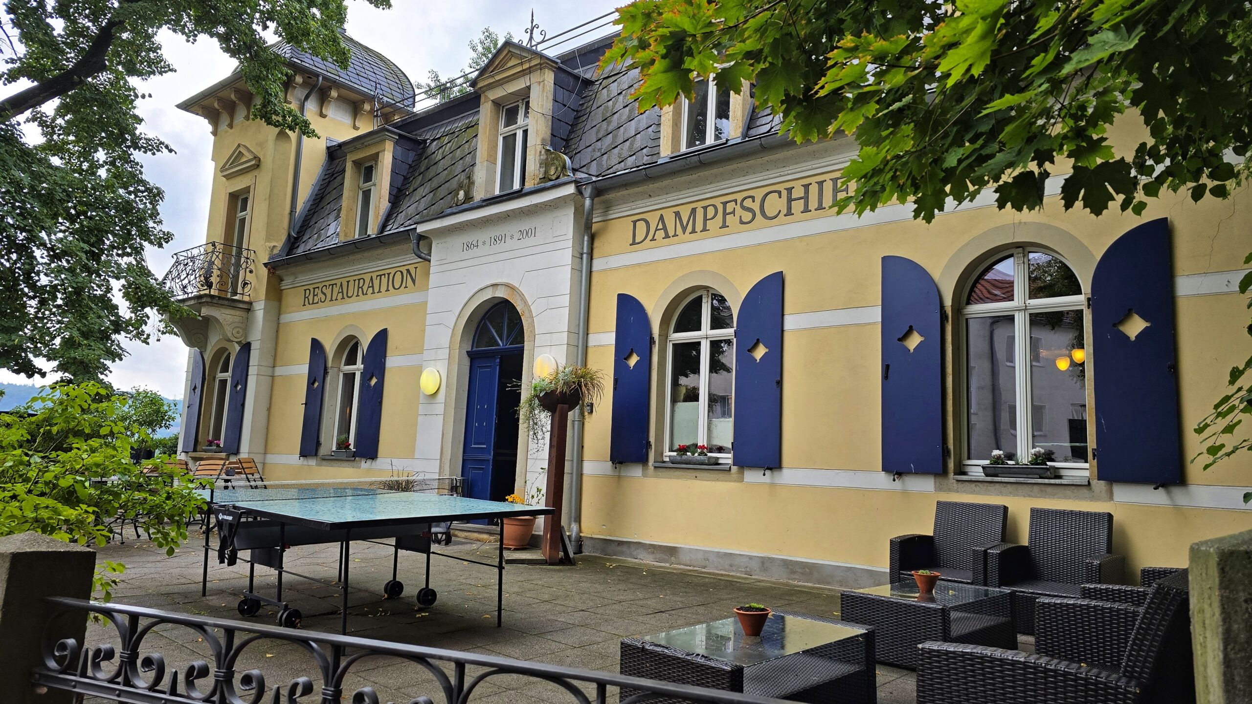 Restauration Dampfschiff in Radebeul West Kötzschenbroda an einem bewölkten Tag im August 2025 mit einer Terasse und einer Tischtennisplatte Bootsanleger