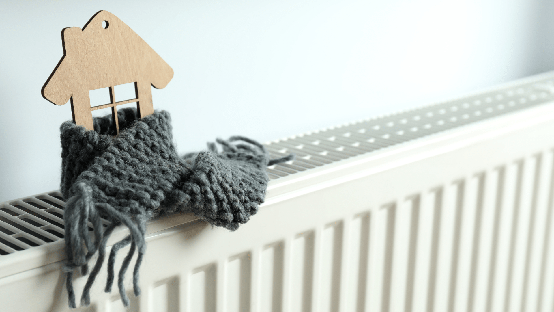 Heizkörper in einer Wohnung Haus mit einem Holzhäuschen mit einem Schal bekleidet auf der Heizung