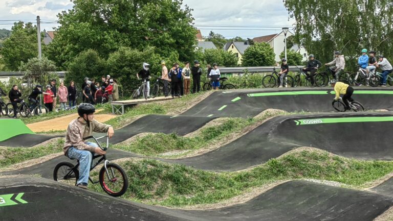 Bikepark in Coswig mit BMX Fahrer im Vordergrund und mehreren Fahrrädern im hintergrund