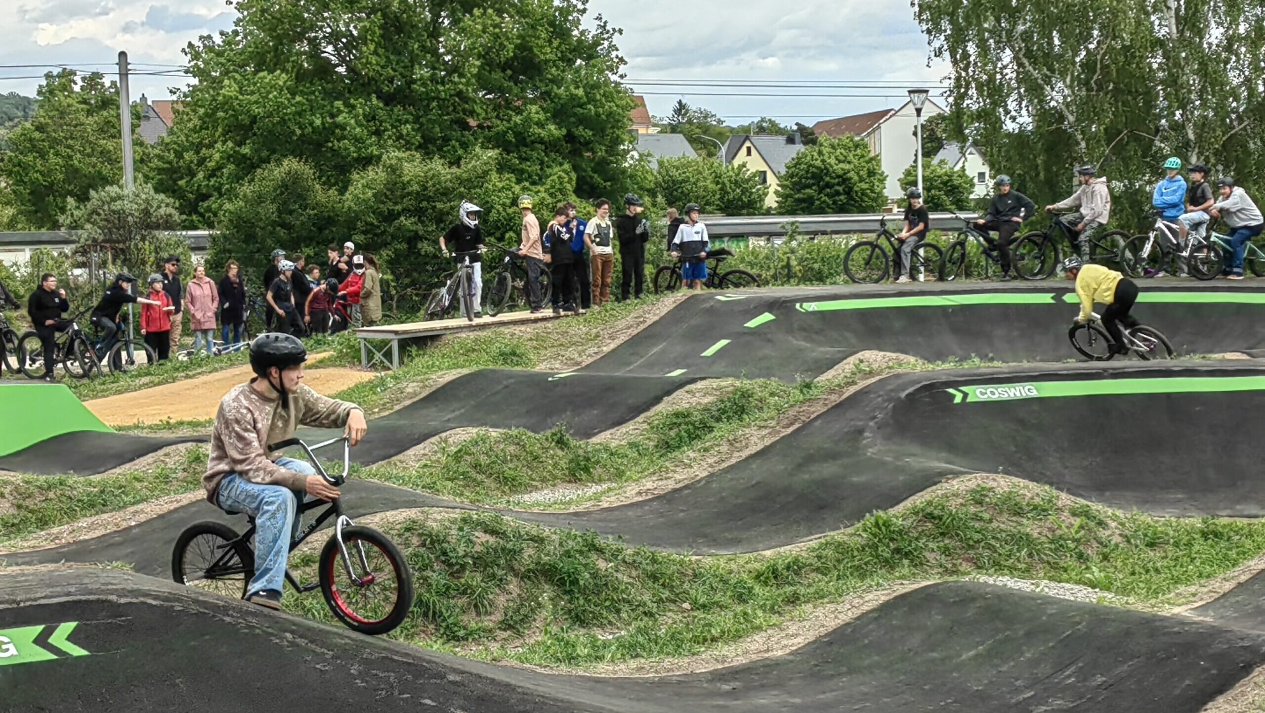 Bikepark in Coswig mit BMX Fahrer im Vordergrund und mehreren Fahrrädern im hintergrund