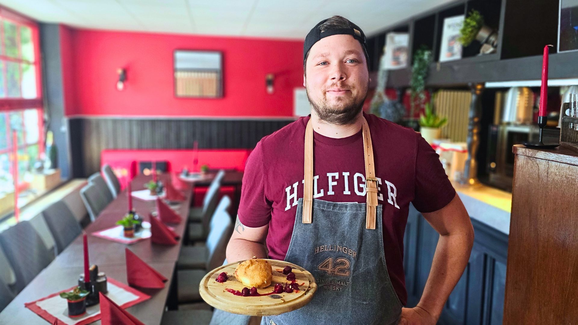 Robert Hentschel in seiner Robert's BBQ Lounge in Radebeul West er hält ein Gericht aus dem Podcast Messer und Gabel in der Hand
