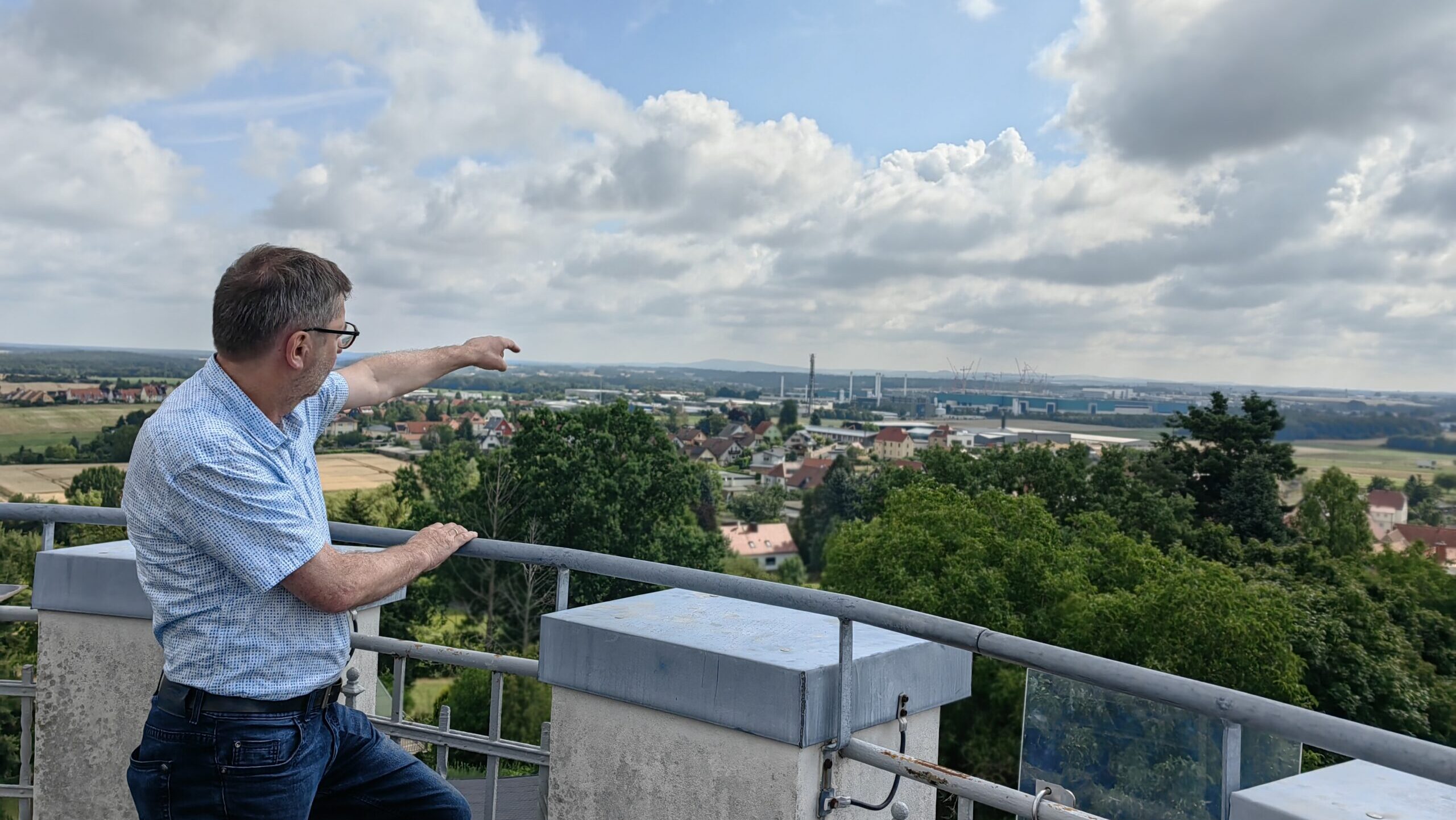Bürgermeister Jörg Hänisch auf der Plattform der Boxdorfer Windmühle - mit Blick das nahe Chipwerk.