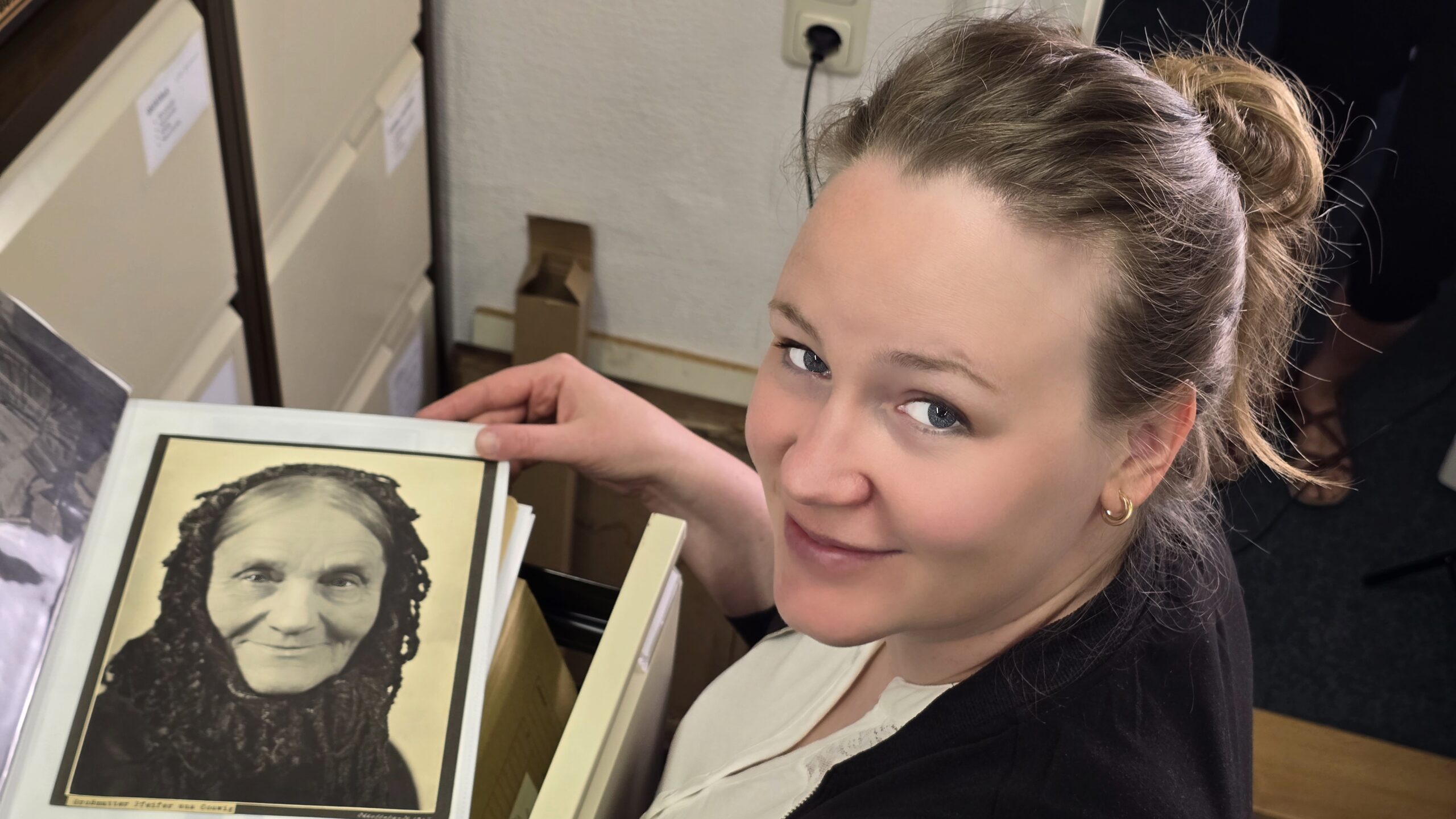 Museumspädagogin Annabell Rink mit dem Erhardt-Foto "Großmutter Pfeifer aus Coswig". Foto © Branczeisz