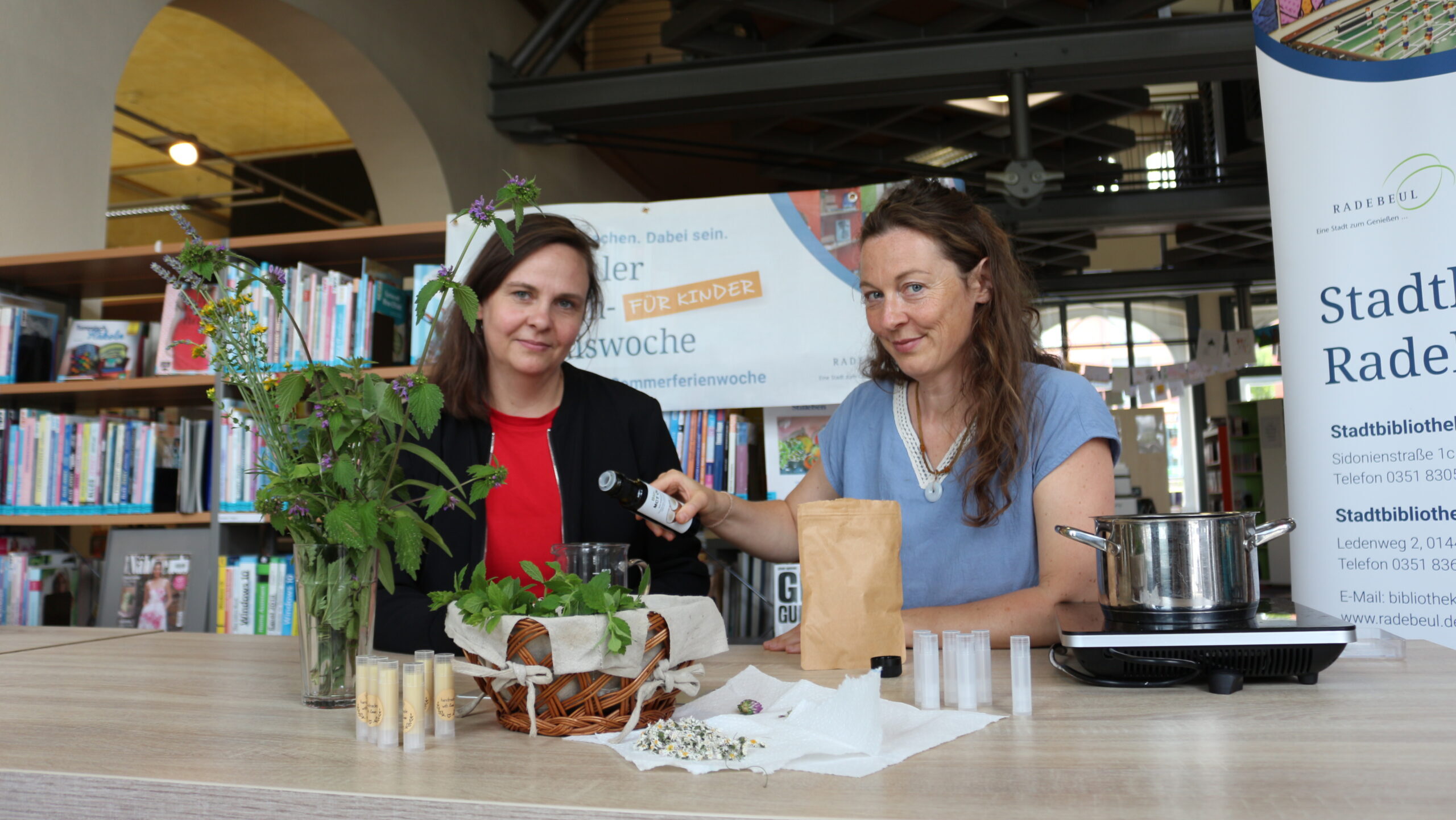 Kathleen Freyer (r.) erklärt Bibliotheksleiterin Katharina Schmidt (l.) die Herstellung eines Lippenpflegebalsams. Foto © Stadt Radebeul
