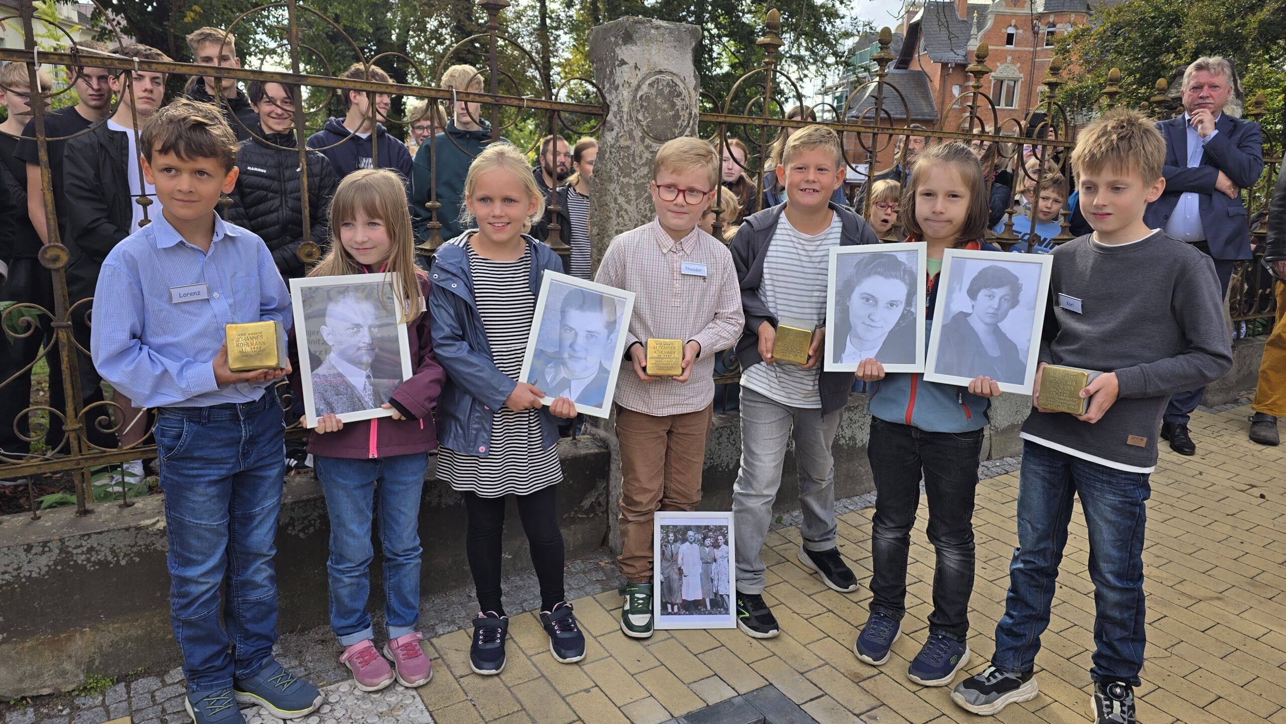 Schüler der 3. Klasse der Schiller-Grundschule mit den Stolpersteinen und den Porträts der vier Kohlmanns. Foto © Branczeisz