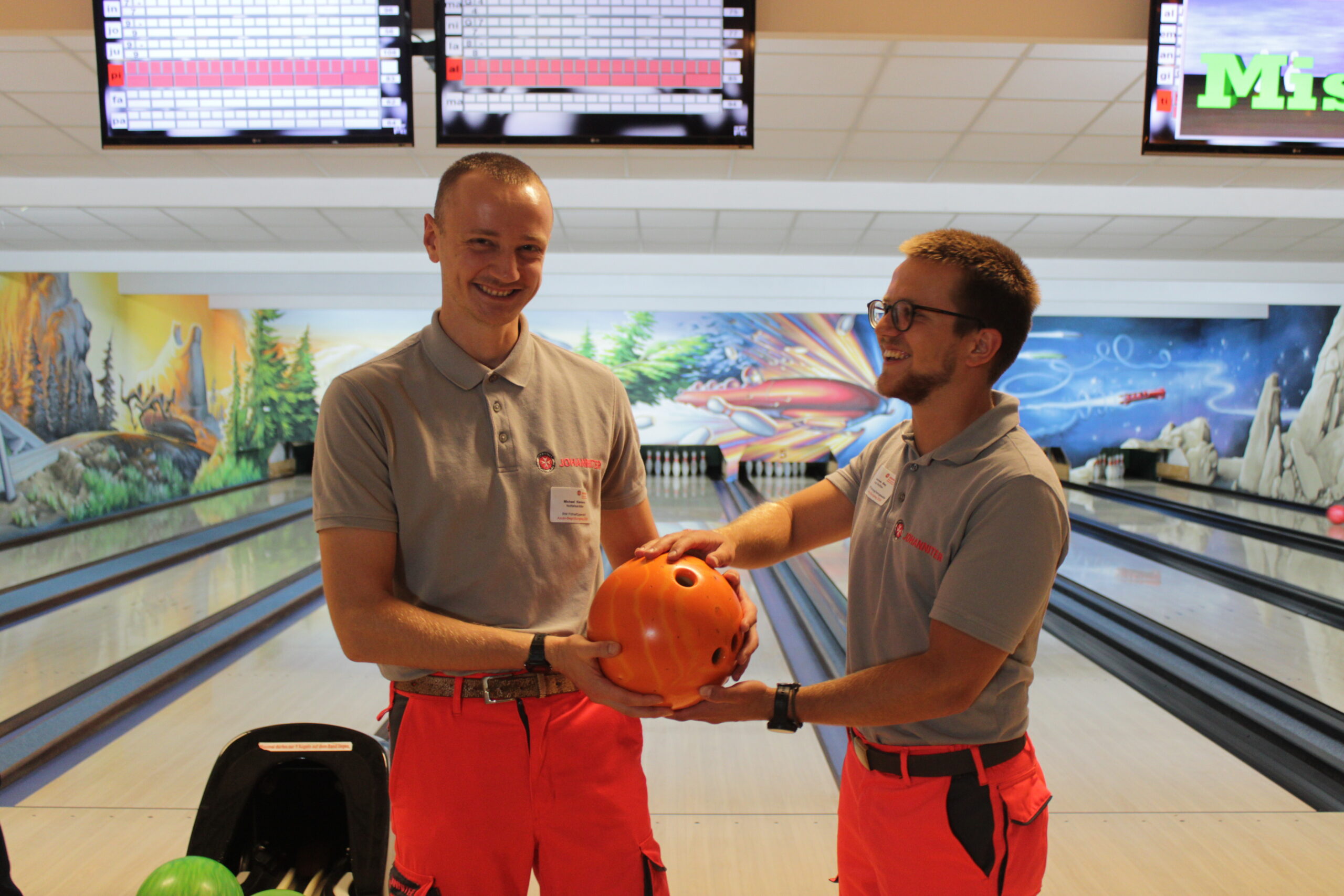 Michael Klemens (Notfallsanitäter, hat seine Ausbildung erfolgreich bestanden, li.) übergibt die Kugel beim gemeinsamen Bowling symbolisch an den neuen Azubi Johannes Bley. Foto © Alexa Langer